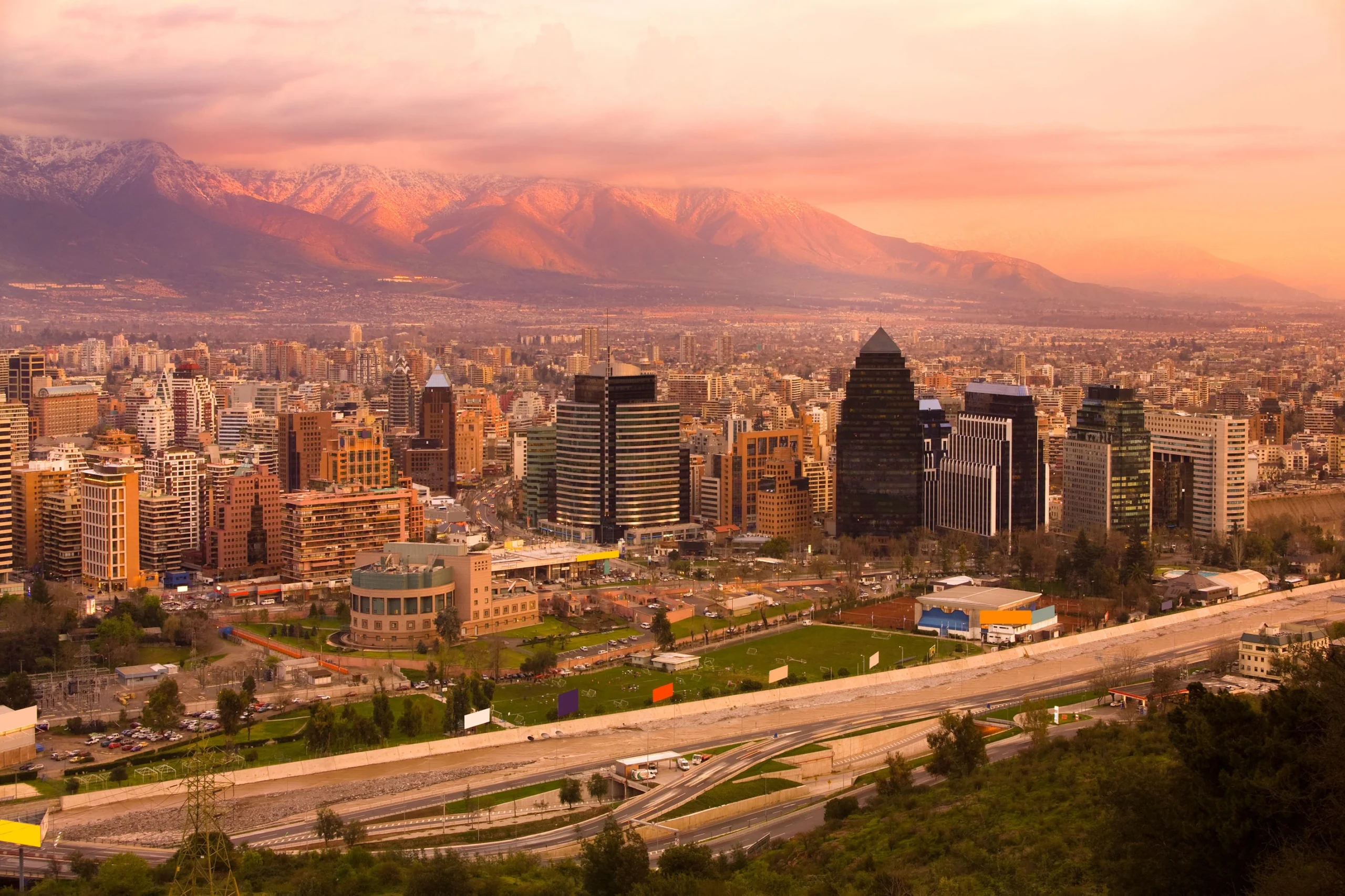 Vista panorámica de Las Condes en Santiago al atardecer, mostrando edificios icónicos y la cordillera, representando el mercado de arriendo 2025
